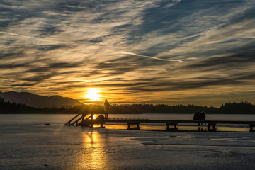 Sonnenuntergang &uuml;ber dem vereisten Kirchsee in Oberbayern