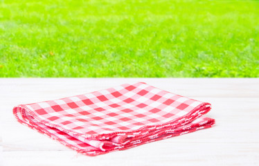 The checkered tablecloth on wooden table.