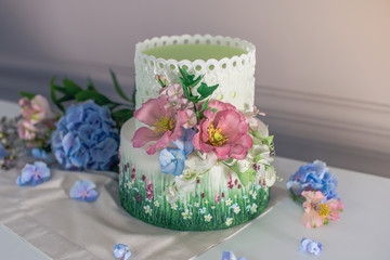 Wedding spring cake decorated with colorful flowers and hydrangeas. Desserts for a festive summer mood