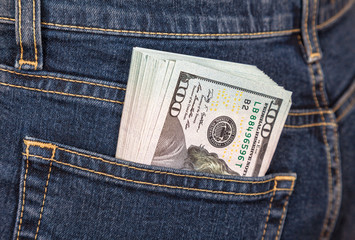 Pile of one hundred american dollar banknotes in the back jeans pocket