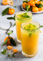 Tangerine juice in glasses on light background