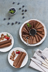 Traditional homemade chocolate pancakes. Celebration of Maslenitsa, Shrovetide. Top view, close-up on rustic vintage wooden background