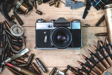 wooden box with vintage camera, bullets for automatic weapon, conceptual expression of the power of...