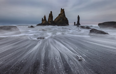 Reynisfjara black sand beach and Reynisdrangar rocks in Iceland at winter