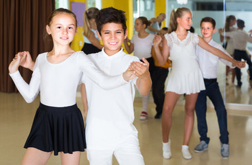 Smiling kids are dancing in pairs
