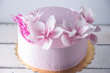Beautiful pink wedding cake decorated with flowers. Concept of elegant holiday desserts