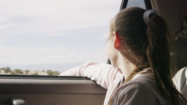 Girl in car with arm outstretched enjoying wind / Moore, Utah, United States
