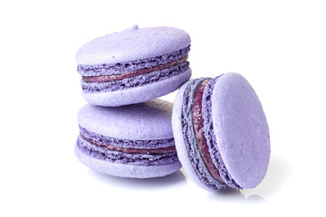 Three violet macarons on white