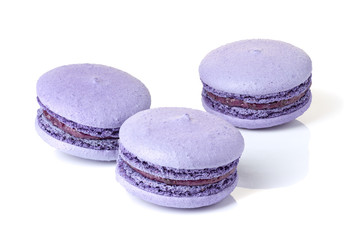Obraz na płótnie Canvas Three violet macarons on white