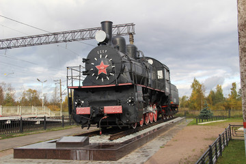 Fototapeta na wymiar The old black engine with a red star and an inscription of USSR in cloudy autumn day near St. Petersburg. Right-side view.