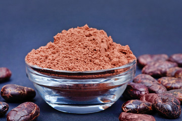 Cacao powder in a bowl on blue background