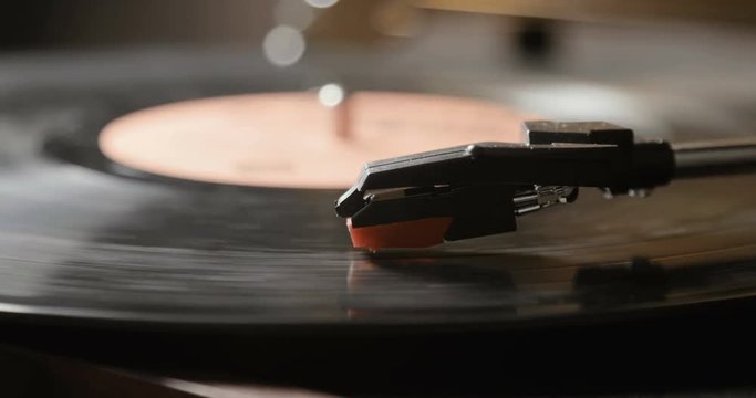 Close-up of using an antiquarian vinyl record player. turntable player,dropping stylus needle on vinyl record playing