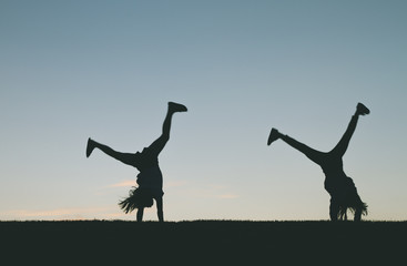 Little girl silhouette doing cartwheels