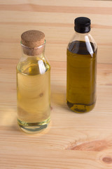 Olive and sunflower oil in glass bottle on wooden background