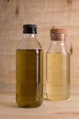 Olive and sunflower oil in glass bottle on wooden background