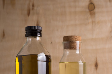 Olive and sunflower oil in glass bottle on wooden background