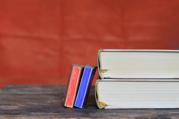 Two small and two big books on wooden table