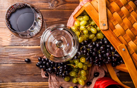 Photo of two wine glasses with wine, grapes