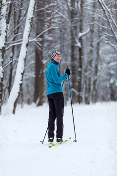 Photo of male skier in blue jacket at winter forest