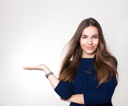 beautiful young woman with long hair wearing wrist watch posing on background with copy space