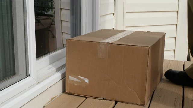 Man Picking Up Package Box Delivered By Post Office Sliding Glass Door