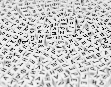 scattered cyrillic letters on white background black and white photo