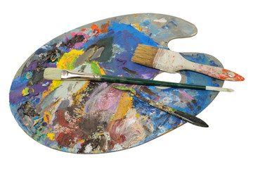 Brushes and painter's knife on the used pallete, white background