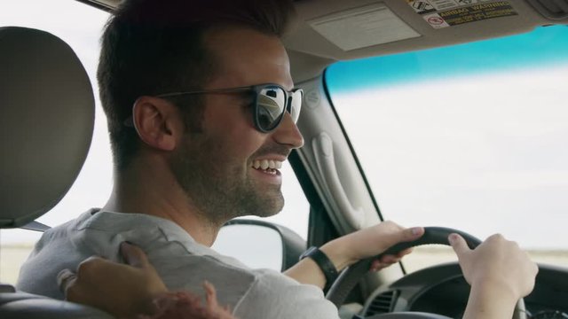 Woman kissing man in car on road trip / Moore, Utah, United States