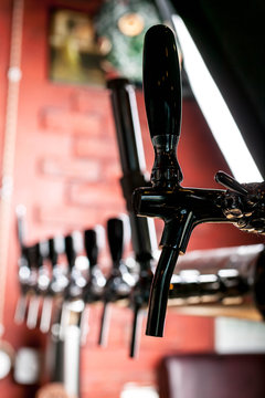 Close-up Of Beer Tap In Bar On A Background Of Red Brick Wall. Selective Focus