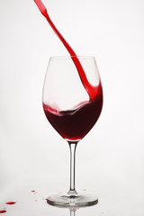 Glass of red wine with splash isolated on white