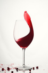 Pomegranate fruit and juice. Glass of cocktail with splash isolated on white