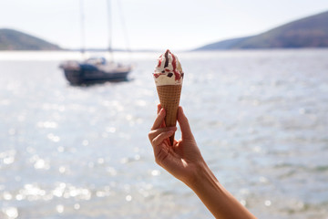 ice cream cones with chocolate and jam in a female hand