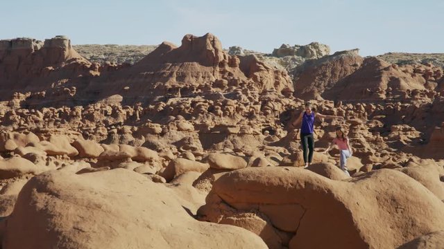 Carefree girls hiking on rock formations in desert / Goblin Valley, Utah, United States