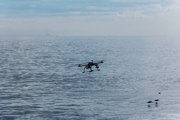 Fototapeta premium Large photography drone flies over popular surfing area in California