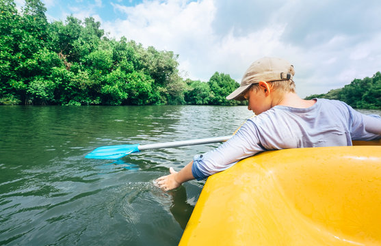 Boy sailing in canoe on tropical lagoon - active leisure time