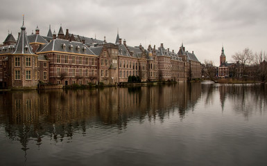 Fototapeta na wymiar Dutch parliament on overcast day reflected in water on nearby lake