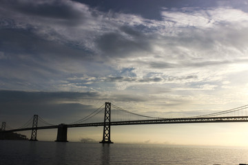 Fototapeta na wymiar Photo of the Bay Bridge in San Francisco, California with clouds in the sky at sunset.
