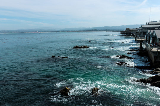 View of waves under a boardwalk in Monterey, California.