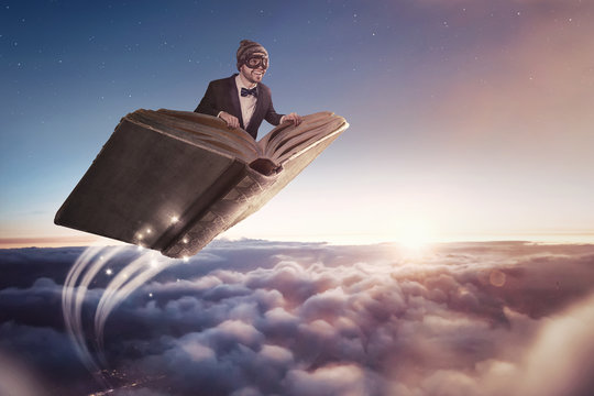 Mann fliegt auf einem Buch über die Wolken