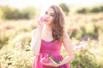 Fototapeta na wymiar Attractive girl 24-26 year old holding rose flowers outdoors. Looking at camera. Spring season. 20s.