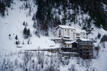 Church in mountains covered with snow and winter forest near Mont Blanc Alpes, Italy