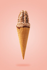 cone of ice cream with chocolate syrup, on a pink background