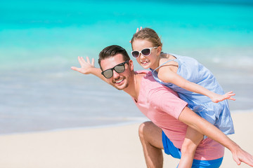 Family fun on white sand. Smiling father and adorable child playing at sandy beach on a sunny day