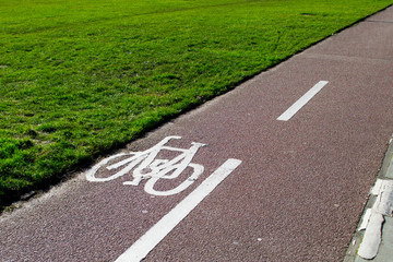 Obraz premium Cycle path next to green grass field