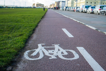 Obraz premium Cycle path beside road and green sports field