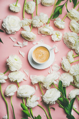 Spring morning concept. Flat-lay of cup of coffee surrounded with white ranunculus flowers over light pink background, top view