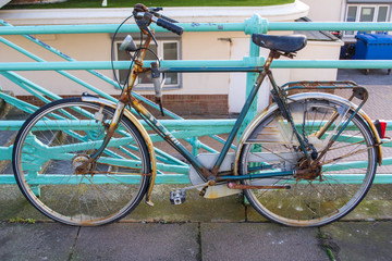 Fototapeta na wymiar Old vintage rusty bike standing up on colorful railings