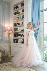 Obraz premium girl in white dress standing by the window
