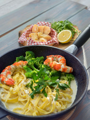 Whole grain pasta with shrimps and cheese on wooden table, top view