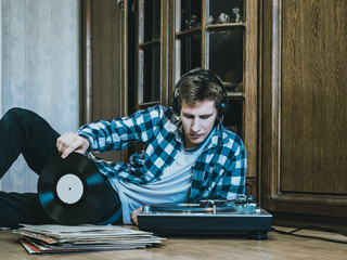 Fototapeta na wymiar portrait of young man at home listening to the vinyl records, relaxing and dreaning